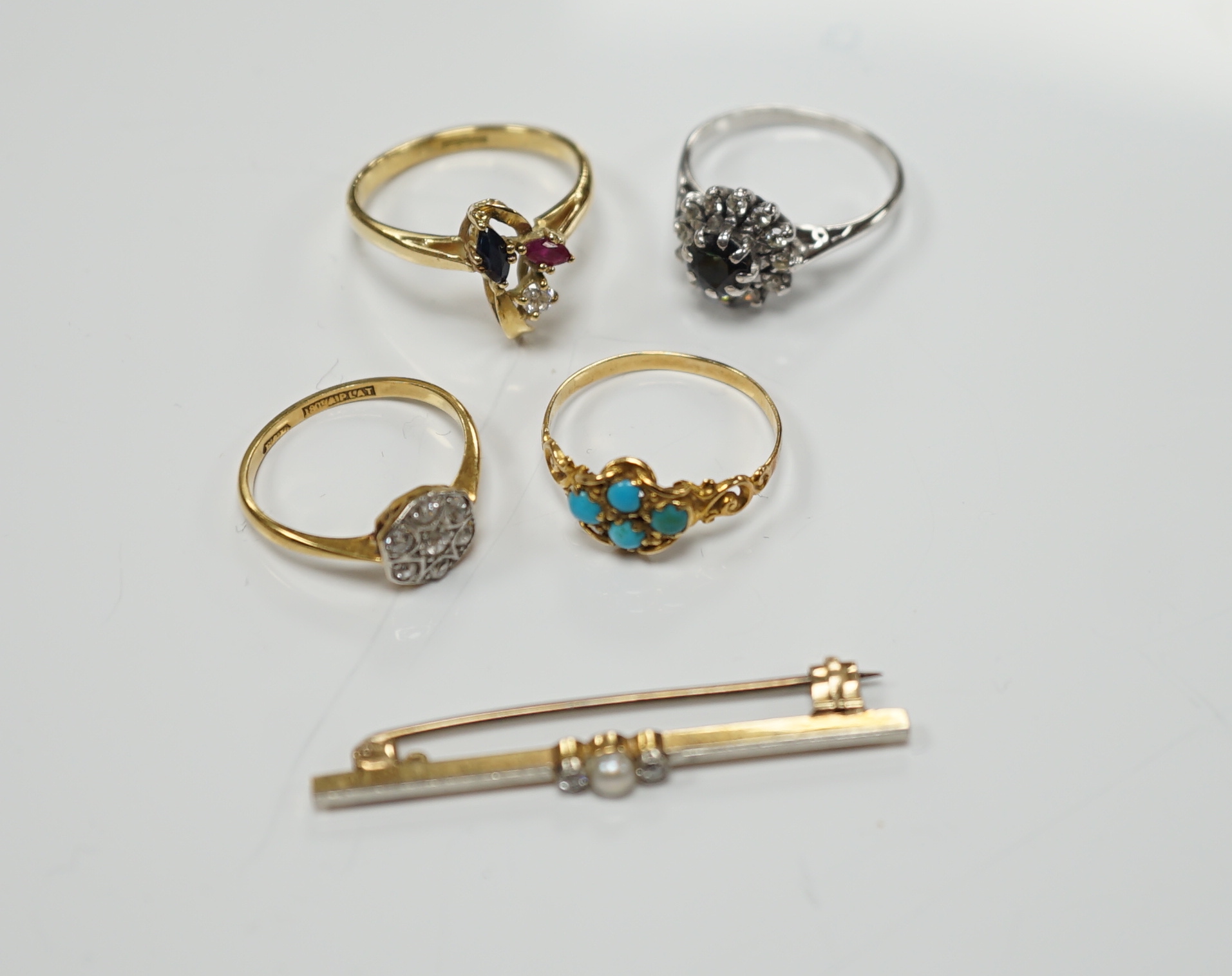 Three assorted 18ct and gem set rings, including 1920's diamond cluster, size K/L, one other early 20th century yellow metal and turquoise cluster set ring and a 15ct, diamond and seed pearl set three stone bar brooch.